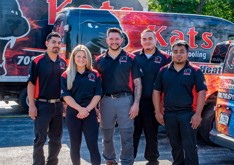 Kats Heating & Cooling employees posing in front of service vehicles