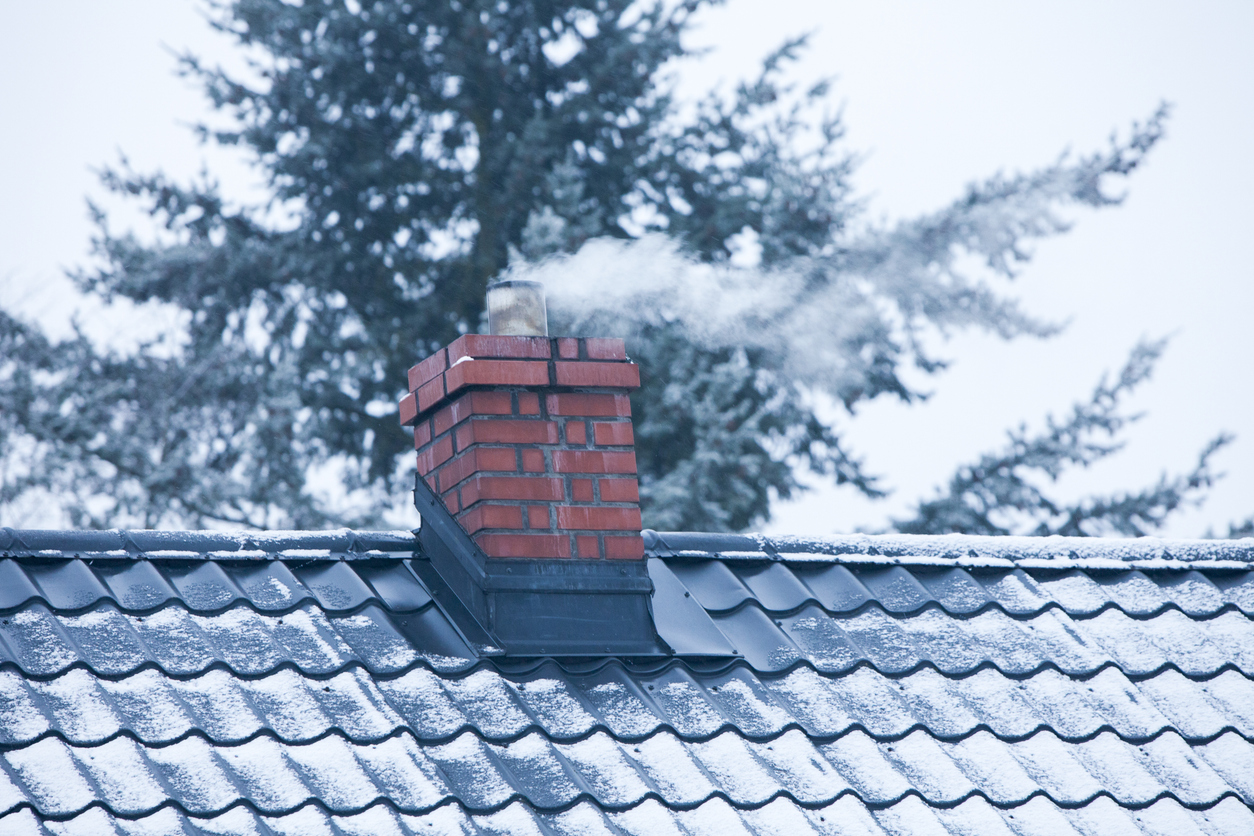 Heating technicians standing beside their Kats Heating & Cooling service vehicles